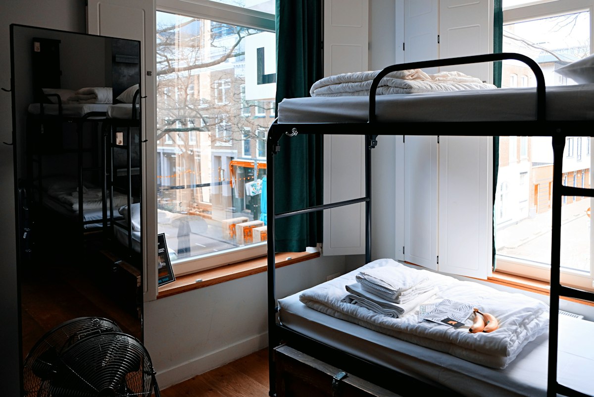 Shared student dormitory room with bunk beds and study desks